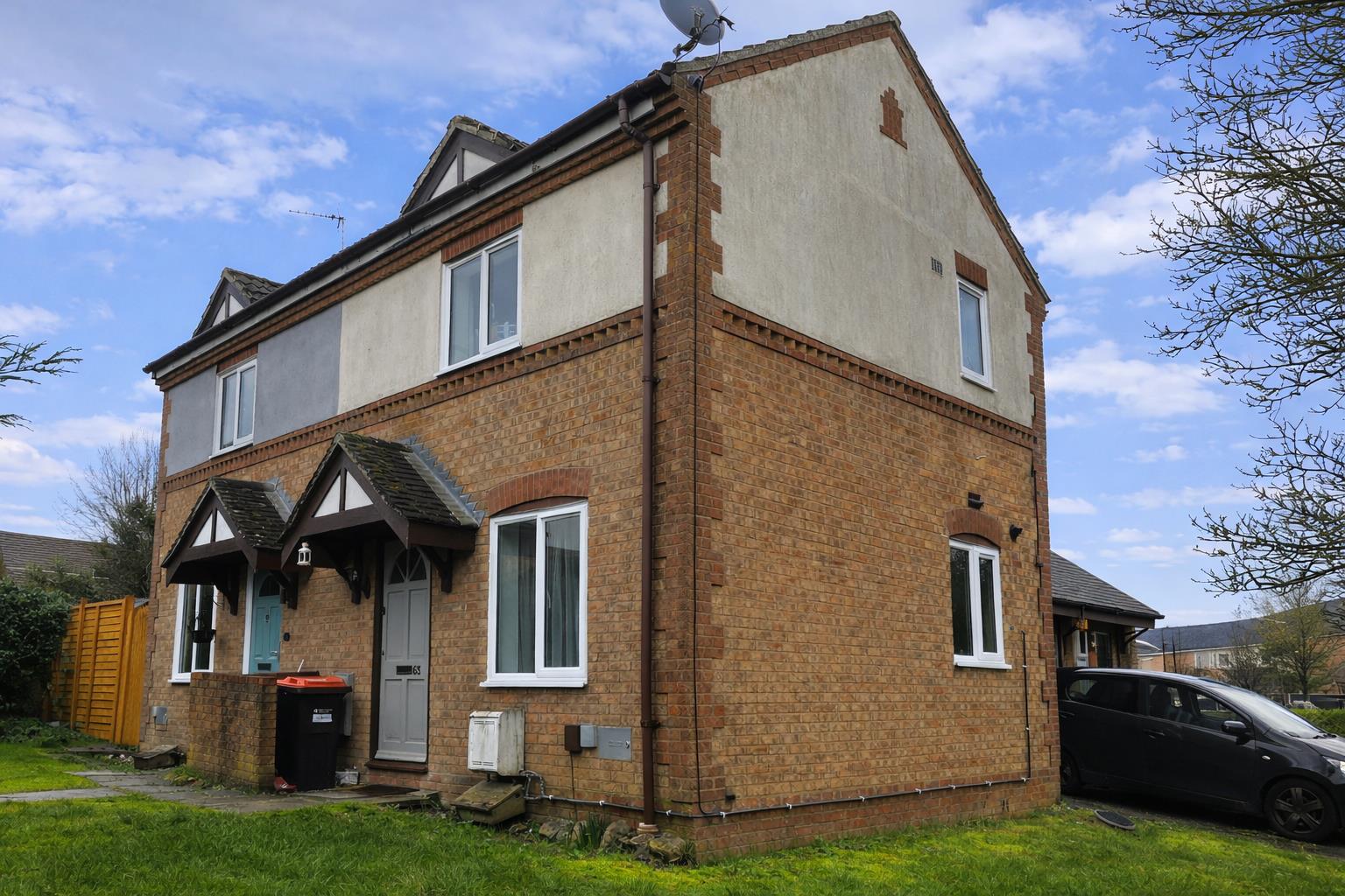 Brick semi-detached house with driveway and garden.